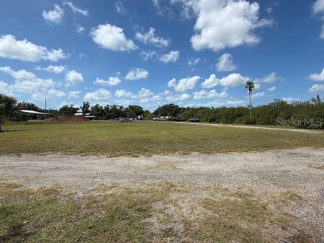 A wide, flat, grassy vacant lot under a blue sky with scattered clouds — 2203 42ND STREET E, BRADENTON, FL