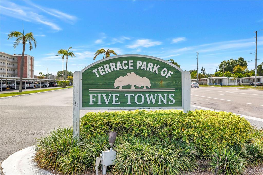 A green sign for Terrace Park of Five Towns stands in a landscaped area — 6190 80TH STREET N UNIT 304, ST PETERSBURG, FL