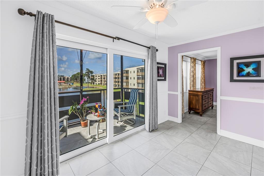 A room with light-colored tile floors and lavender walls opens to a screened-in balcony — 6190 80TH STREET N UNIT 304, ST PETERSBURG, FL