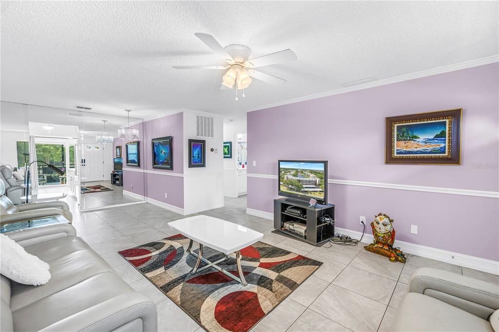 A living room features light purple walls, a white ceiling fan, and a patterned area rug — 6190 80TH STREET N UNIT 304, ST PETERSBURG, FL