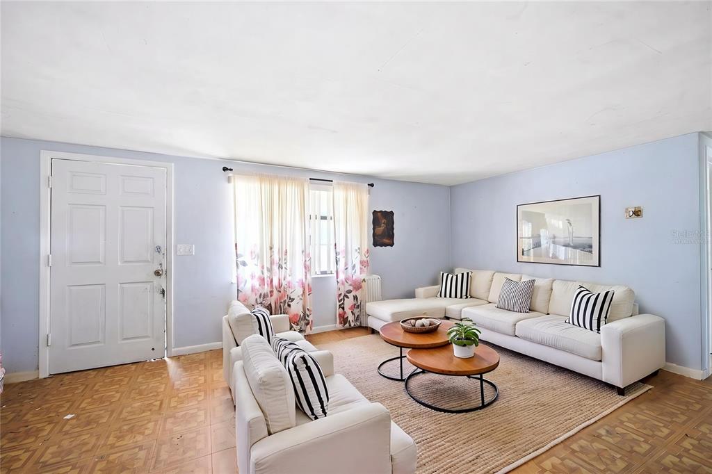 A living room features light blue walls, a white sectional sofa, and a patterned rug — 10 S JACKSON STREET, BEVERLY HILLS, FL