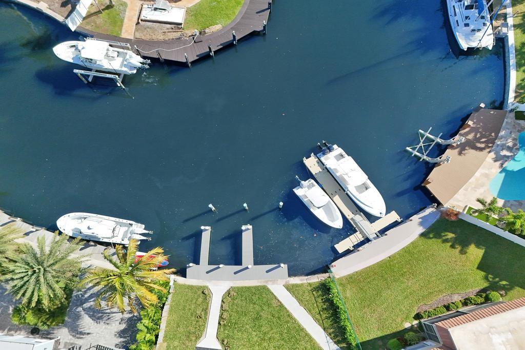An aerial view shows a canal with several boats docked at private piers and seawalls — 840 SE 22nd Avenue, Pompano Beach FL 33062, POMPANO BEACH, FL