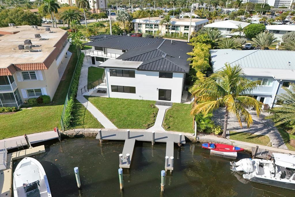 An aerial view shows a modern white house with a black metal roof and private dock — 840 SE 22nd Avenue, Pompano Beach FL 33062, POMPANO BEACH, FL