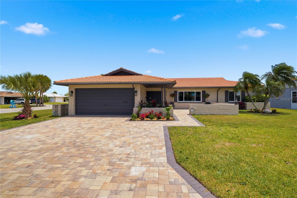 A single-story house with a tiled roof, a paved driveway, and a front garden — 5016 DORY DRIVE, NEW PORT RICHEY, FL