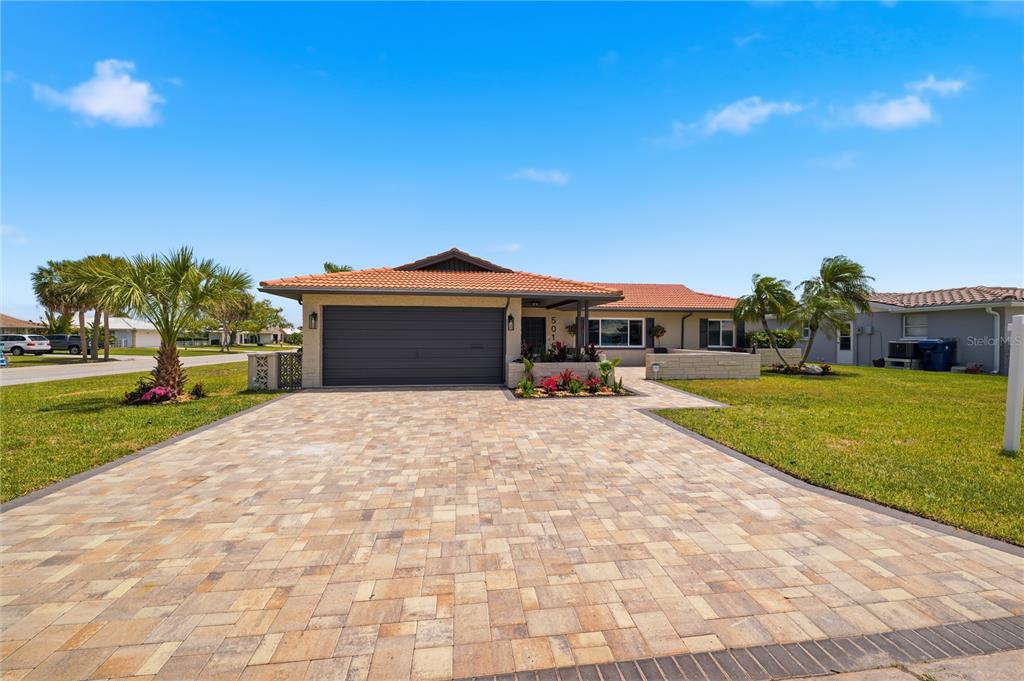 A single-story house with a tiled roof, a paver driveway, and a two-car garage — 5016 DORY DRIVE, NEW PORT RICHEY, FL