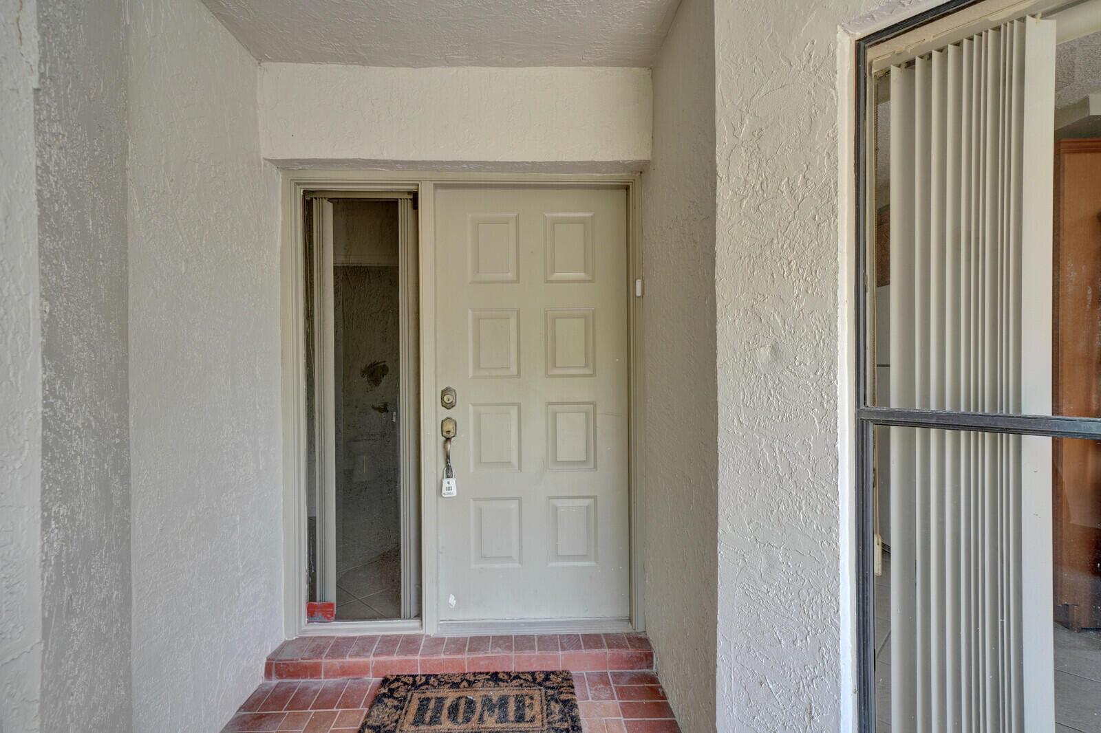 A beige front door with a side window and a brick entryway mat — 6371 Toulon Drive, Boca Raton FL 33433, BOCA RATON, FL