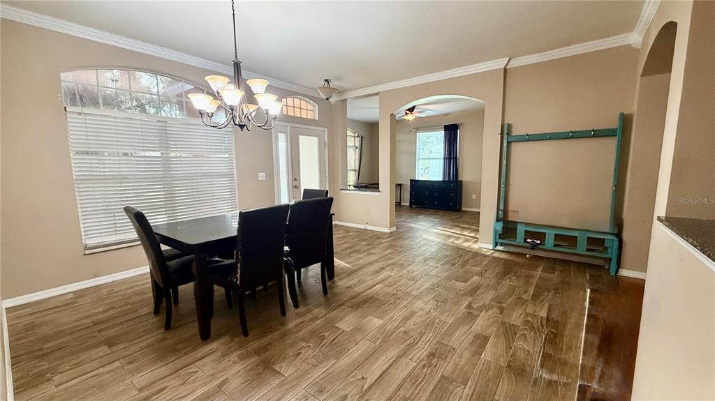 A dining room with wood-look tile flooring, a chandelier, and a large blue storage unit — 3806 TRIPLE JUMP STREET, VALRICO, FL