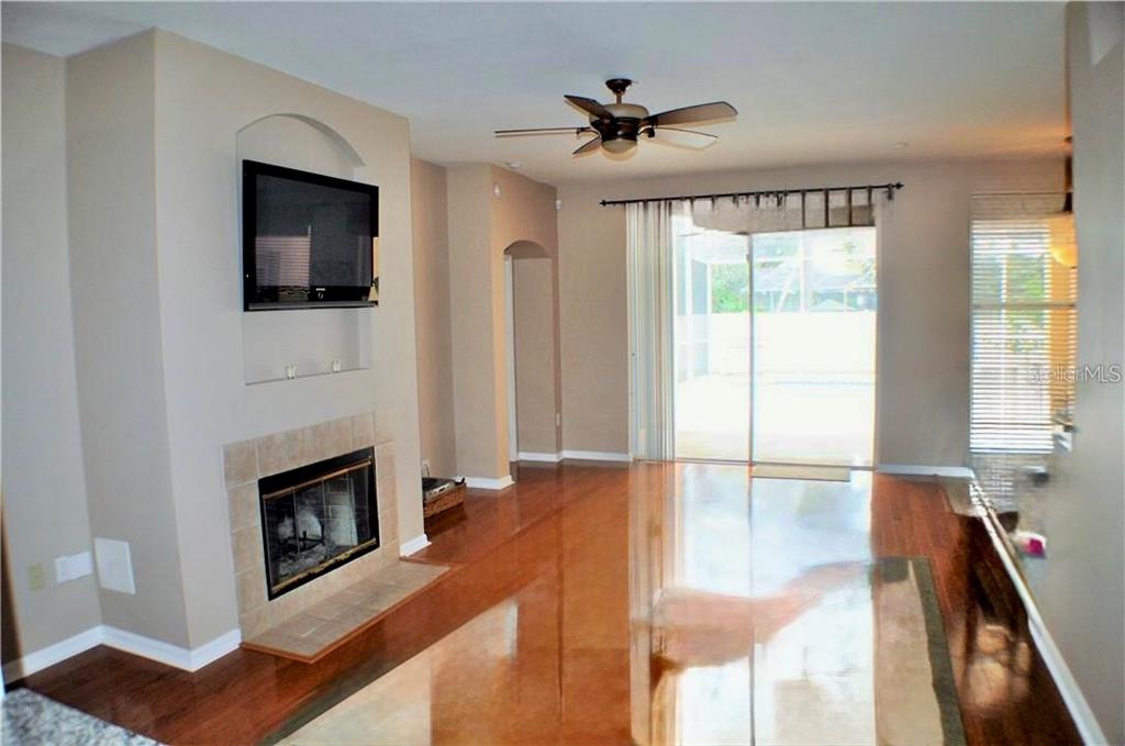 A kitchen features wood cabinets, granite countertops, stainless steel appliances, and tile flooring — 3806 TRIPLE JUMP STREET, VALRICO, FL