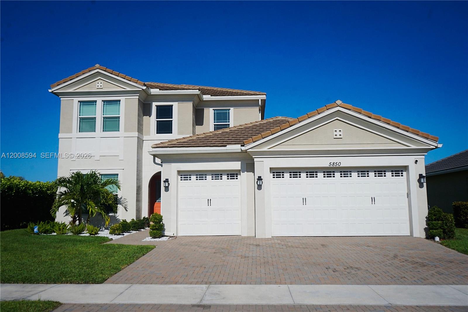 An aerial view shows a two-story suburban house with a tiled roof and brick driveway — 5850 Whippoorwill Cir, Westlake FL 33470, WESTLAKE, FL
