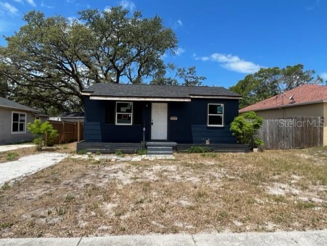 A dark blue, single-story house with a white front door and a small wooden porch — 1931 44TH STREET S, ST PETERSBURG, FL