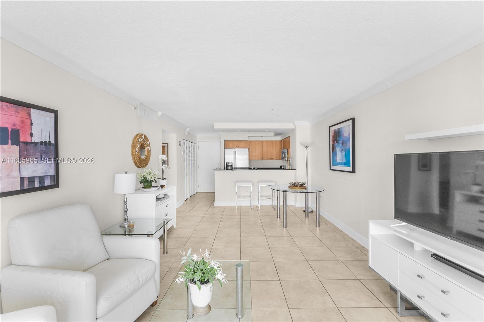 A high-angle view shows a sandy beach and ocean between two tall residential buildings — 6917 Collins Ave # 1505, Miami Beach FL 33141, MIAMI BEACH, FL