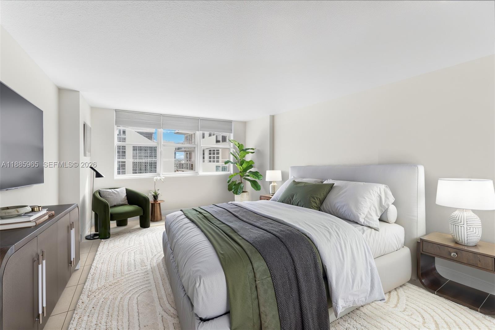 A living room with tile floors flows into an open kitchen with a breakfast bar — 6917 Collins Ave # 1505, Miami Beach FL 33141, MIAMI BEACH, FL