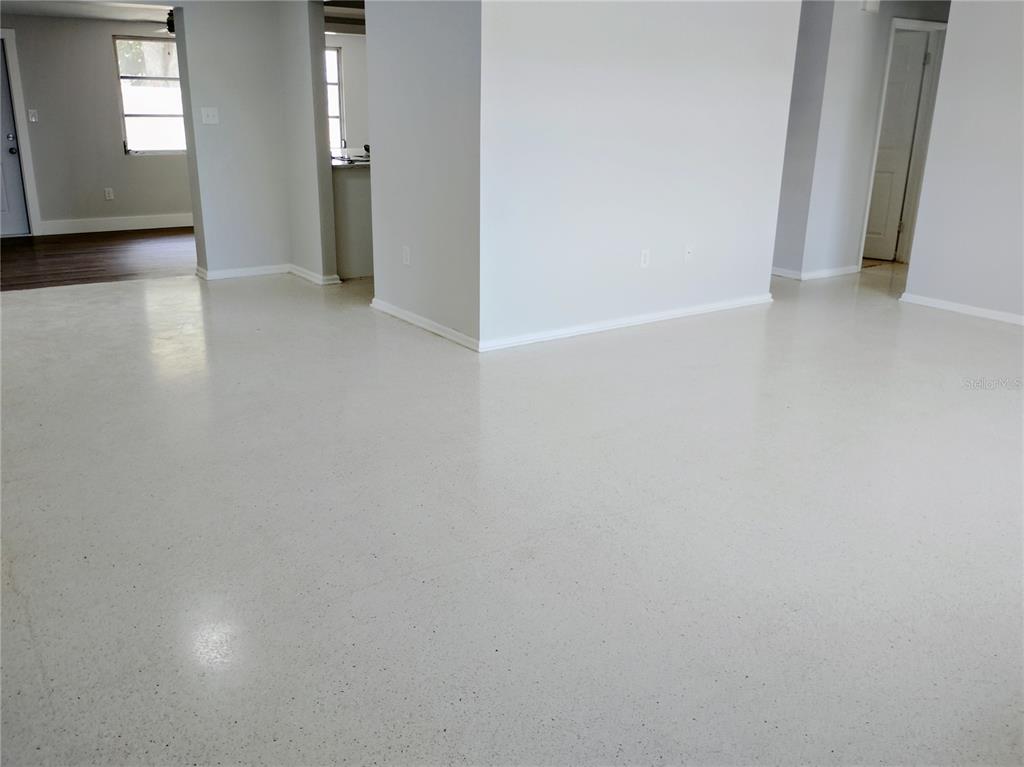 An interior view of a room with light gray walls and speckled white flooring — 5004 22ND AVENUE W, BRADENTON, FL