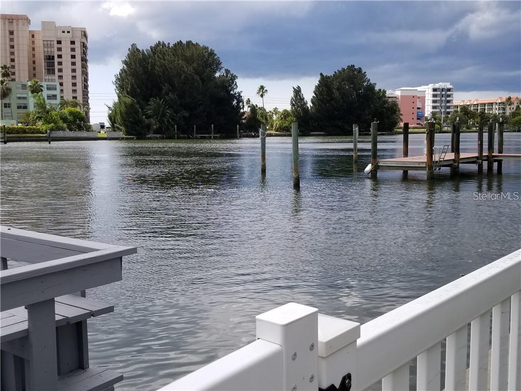 A view of a calm waterway with a wooden dock and surrounding apartment buildings — 4000 BELLE VISTA DRIVE, ST PETERSBURG, FL