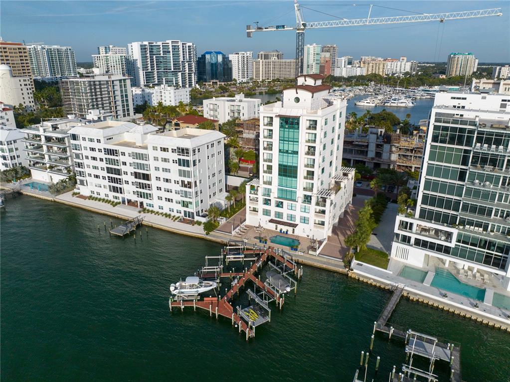 An aerial view of a waterfront condominium building with a private dock and boat slips — 258 GOLDEN GATE POINT UNIT 701, SARASOTA, FL