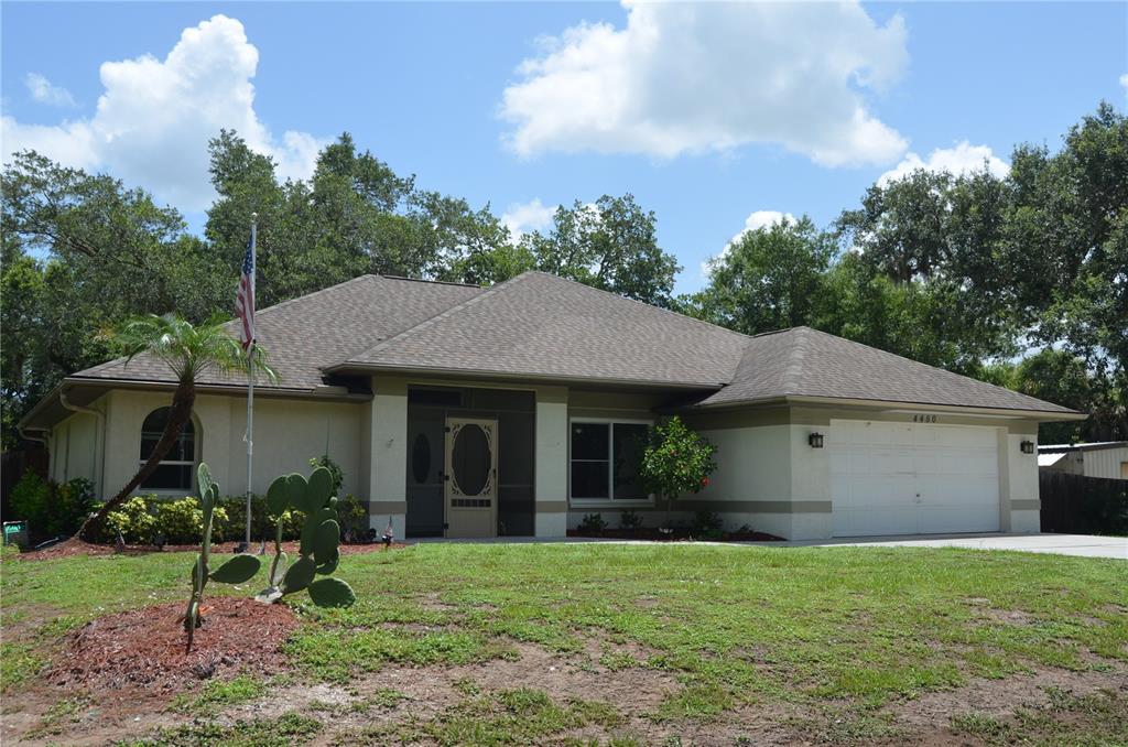 A single-story house with a white garage, a screened entryway, and a cactus in the yard — 4450 JODY AVENUE, NORTH PORT, FL