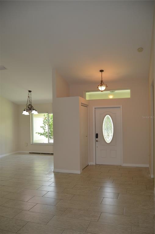 An entryway with tile flooring, a white front door, and a hanging light fixture — 4450 JODY AVENUE, NORTH PORT, FL