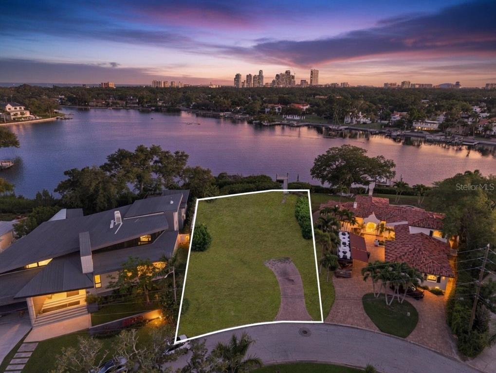 An aerial view shows a vacant waterfront lot situated between two large residential homes — 1026 MONTEREY BOULEVARD NE, ST PETERSBURG, FL
