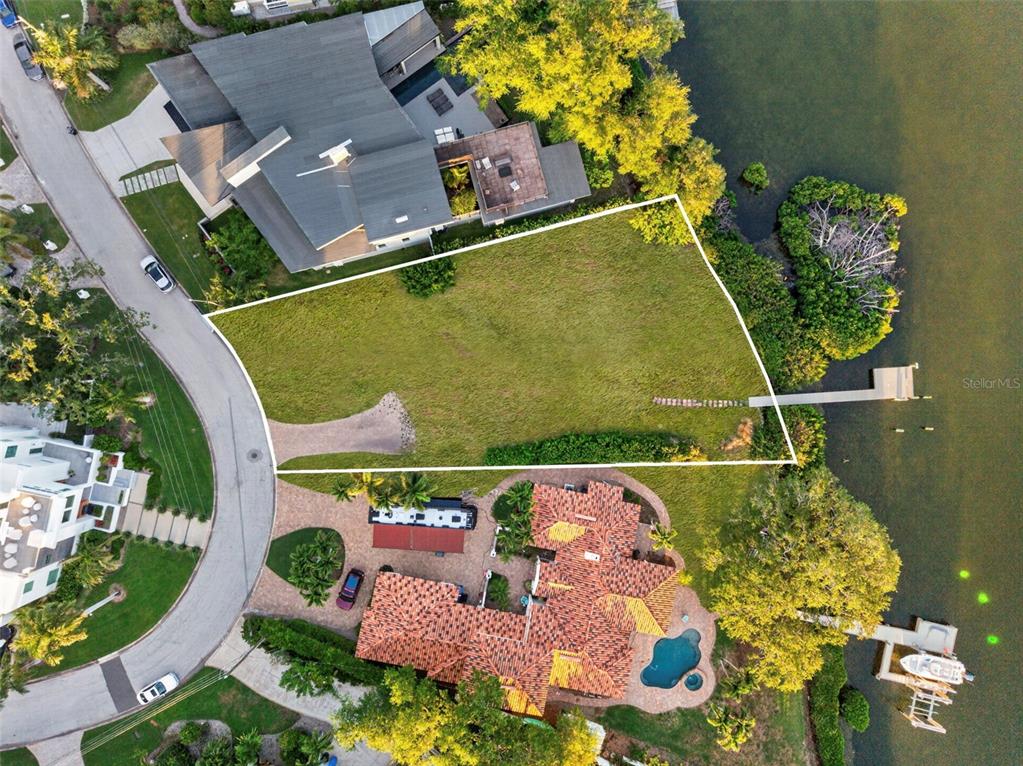 An aerial view shows a vacant waterfront lot situated between two large residential properties — 1026 MONTEREY BOULEVARD NE, ST PETERSBURG, FL