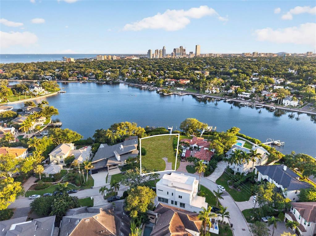An aerial view shows a vacant waterfront lot outlined in white within a residential neighborhood — 1026 MONTEREY BOULEVARD NE, ST PETERSBURG, FL