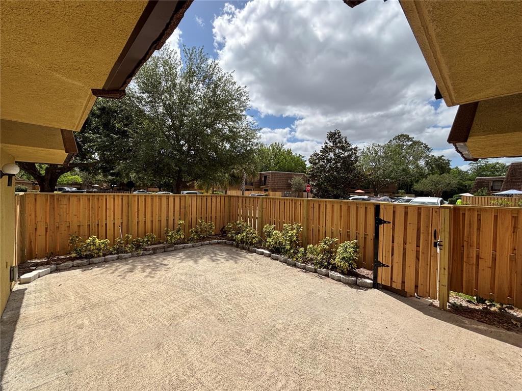 A concrete patio is enclosed by a new wooden privacy fence and a small gate — 5341 BAMBOO COURT UNIT 418, ORLANDO, FL