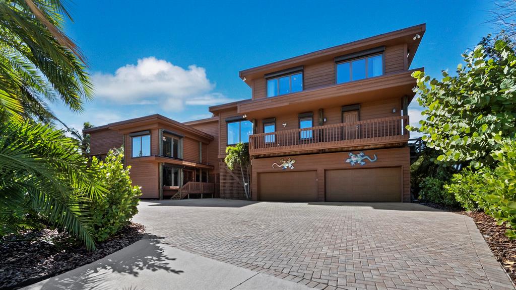 A three-story brown wooden house with a two-car garage and a brick paver driveway — 6685 GULF OF MEXICO DRIVE, LONGBOAT KEY, FL