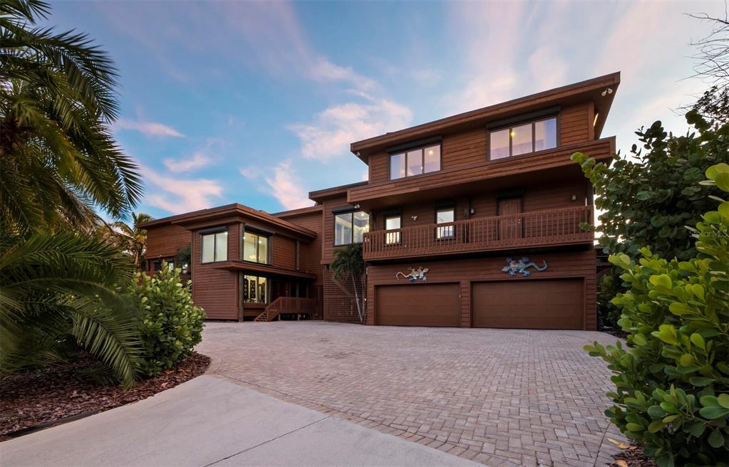 A three-story brown wooden house features a paved driveway and a two-car garage — 6685 GULF OF MEXICO DRIVE, LONGBOAT KEY, FL