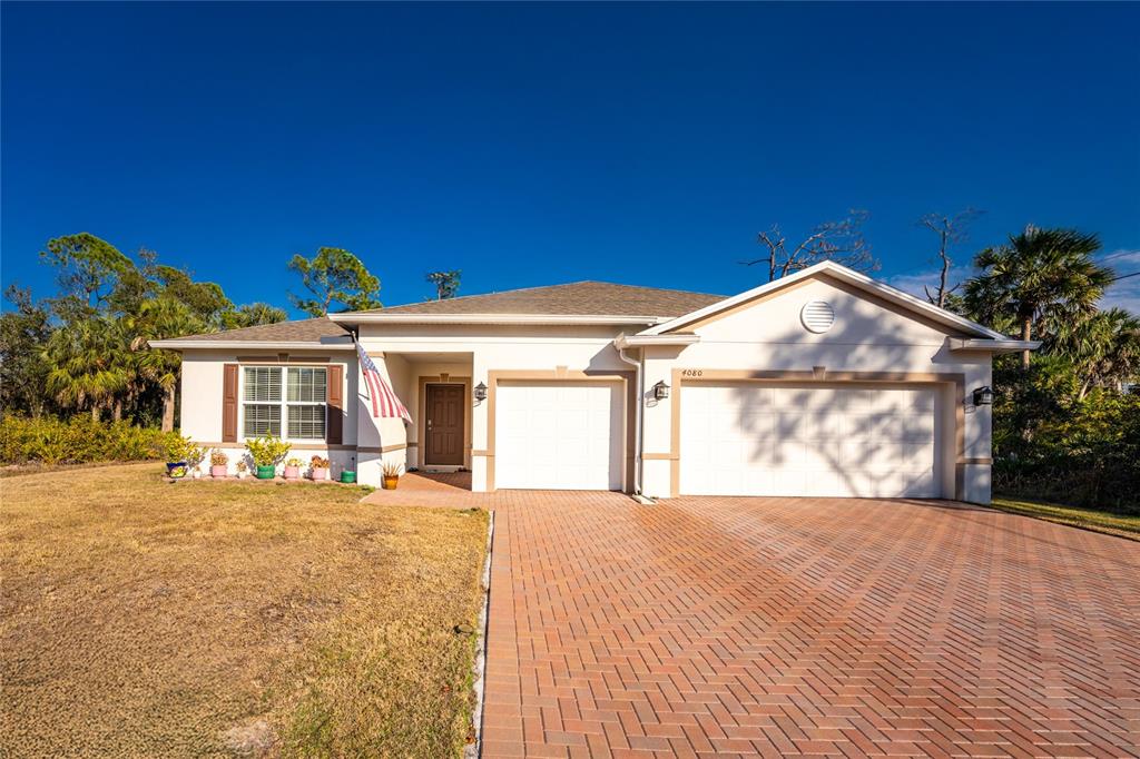 A single-story house with a two-car garage and a brick paver driveway — 4080 COLLINGSWOOD BOULEVARD, PORT CHARLOTTE, FL