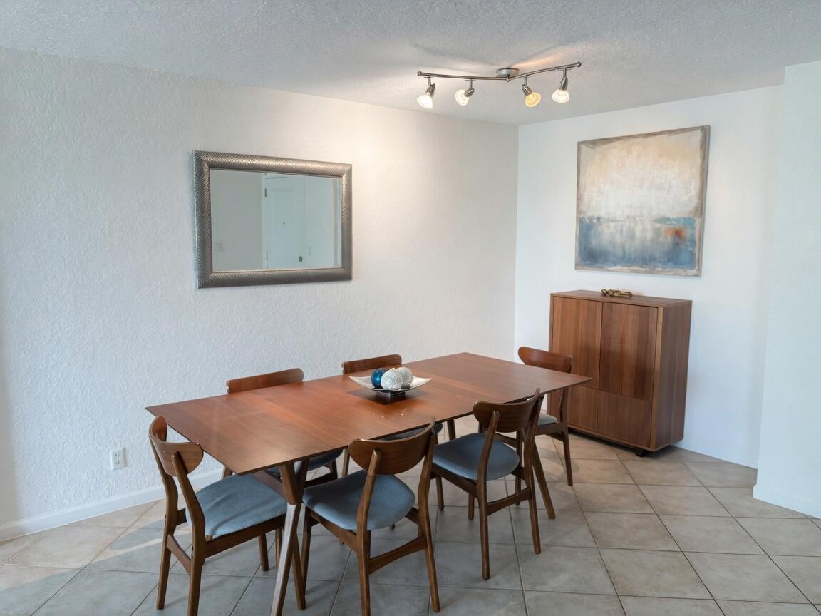A dining room with a wooden table, six chairs, a mirror, and a storage cabinet — 1000 Spanish River Road # 4p, Boca Raton FL 33432, BOCA RATON, FL