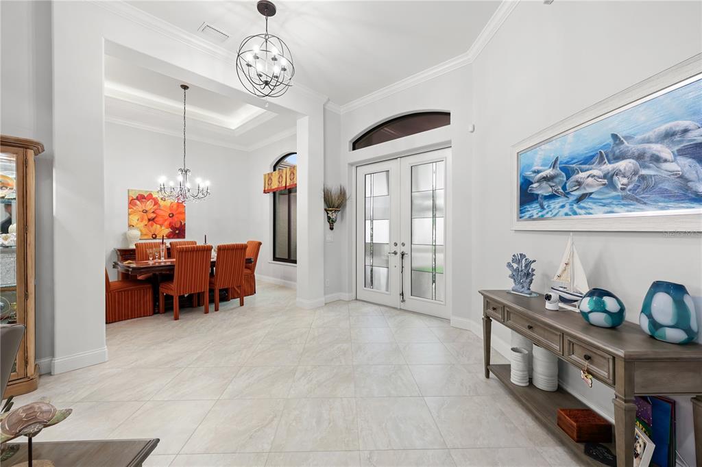 A bright entryway features tile floors, a dining area, and a large dolphin wall painting — 5072 SAN MASSIMO DRIVE, PUNTA GORDA, FL