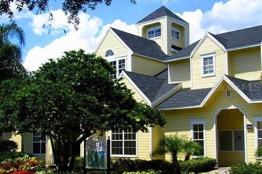 A yellow two-story building with a dark shingled roof and multiple gables — 1023 S HIAWASSEE ROAD UNIT 4013, ORLANDO, FL