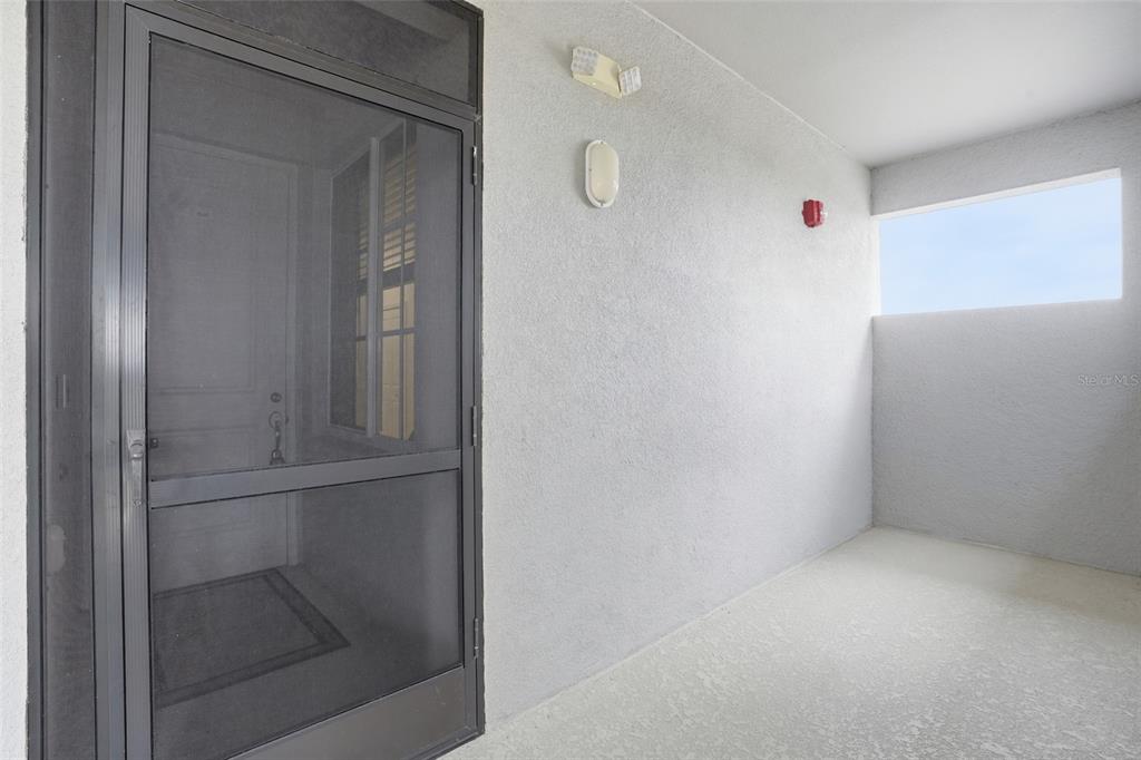 A covered balcony features a screen door, textured walls, and a small rectangular window — 14131 HERITAGE LANDING BOULEVARD UNIT 846, PUNTA GORDA, FL