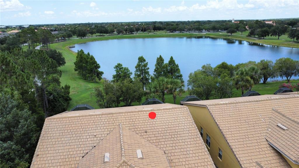 An aerial view shows a tiled roof overlooking a large lake and surrounding green space — 2316 PALM TREE DRIVE, KISSIMMEE, FL