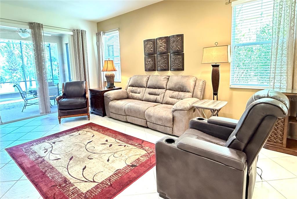 A living room features a beige sofa, two armchairs, a patterned rug, and tile flooring — 2316 PALM TREE DRIVE, KISSIMMEE, FL