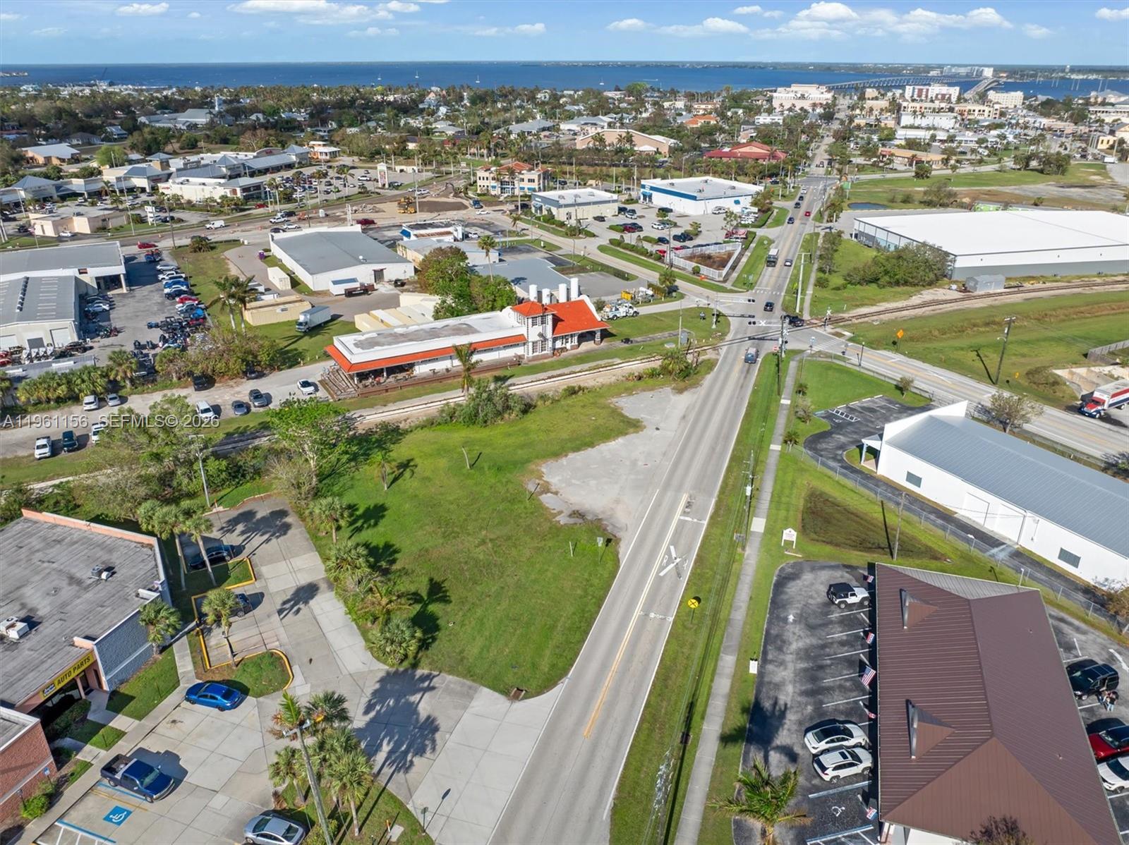 An aerial view shows a commercial area with buildings, parking lots, and a railroad crossing — 1013 Taylor Rd, Punta Gorda FL 33950, PUNTA GORDA, FL