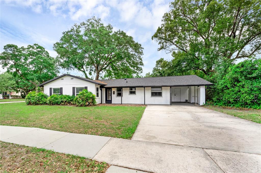 A single-story white brick house with a dark roof and an attached carport — 2366 COLDSTREAM DRIVE, WINTER PARK, FL