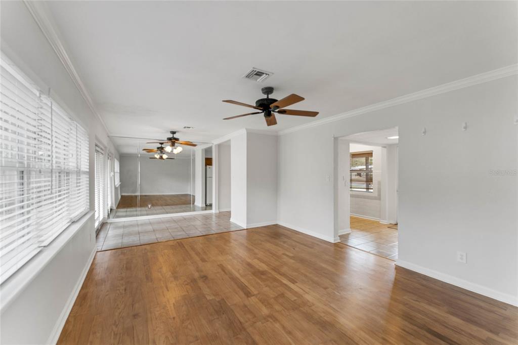A living room with hardwood floors, a ceiling fan, and a mirrored wall section — 2366 COLDSTREAM DRIVE, WINTER PARK, FL