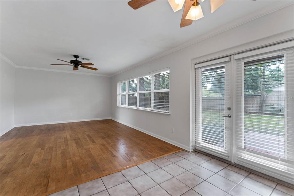 An empty room features hardwood flooring, tile, a ceiling fan, and glass doors to a yard — 2366 COLDSTREAM DRIVE, WINTER PARK, FL