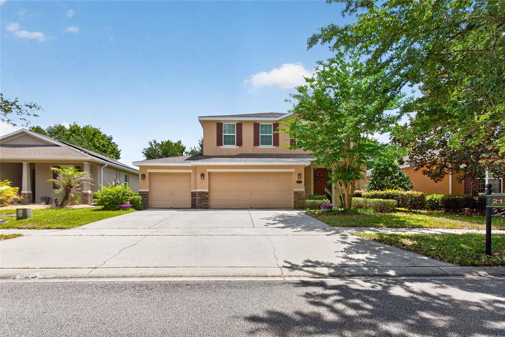 A two-story suburban house with a three-car garage and a concrete driveway — 213 VICTORIA TRAILS BOULEVARD, DELAND, FL