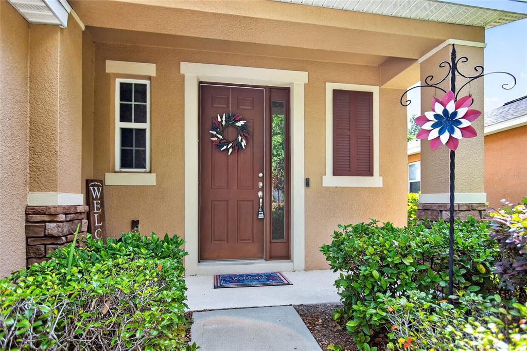 A front entrance features a brown door with a wreath, a welcome sign, and landscaping — 213 VICTORIA TRAILS BOULEVARD, DELAND, FL