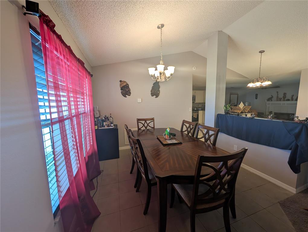 A living room features a fireplace, a television, a ceiling fan, and tile flooring — 770 SWEETBRIER DRIVE, DELTONA, FL