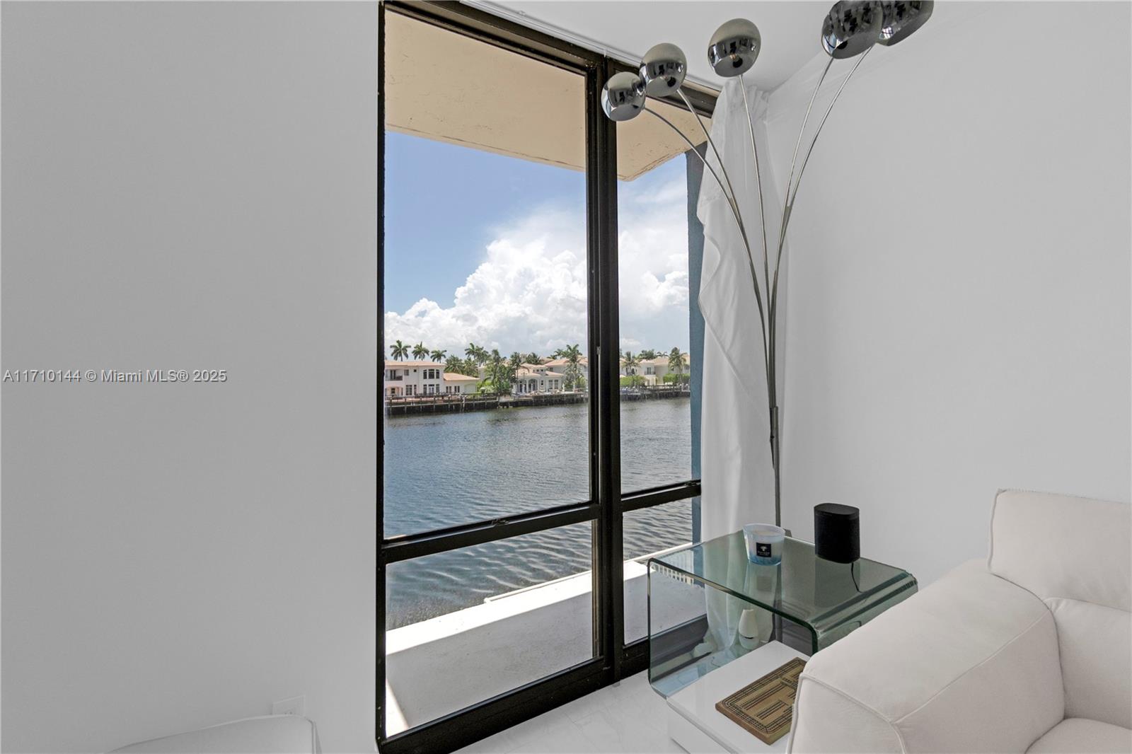 A living area features a floor-to-ceiling window overlooking a canal and waterfront homes — 1600 S Ocean Dr # 2F, Hollywood FL 33019, HOLLYWOOD, FL