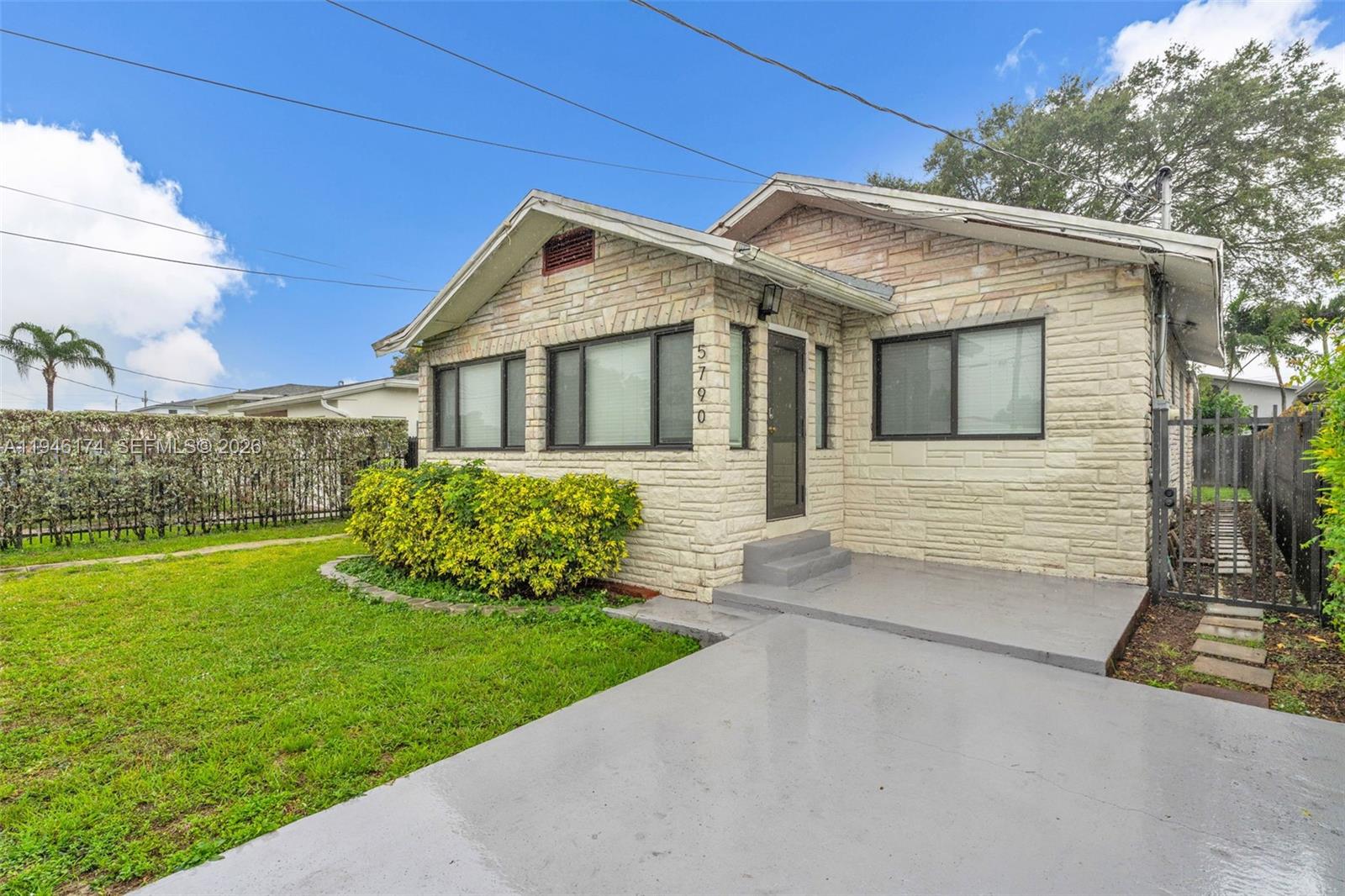 A single-story house with light-colored stone siding, a concrete driveway, and a small front lawn — 5790 SW 5th St, Miami FL 33144, MIAMI, FL