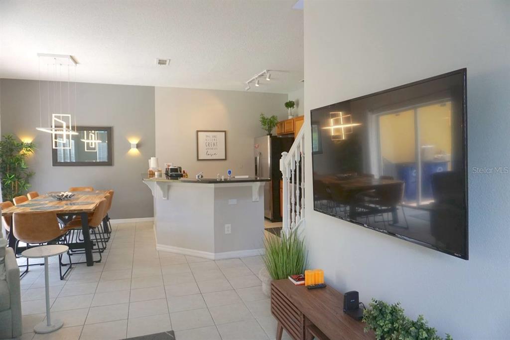A dining area and kitchen with a breakfast bar are visible from the living room — 3162 YELLOW LANTANA LANE, KISSIMMEE, FL