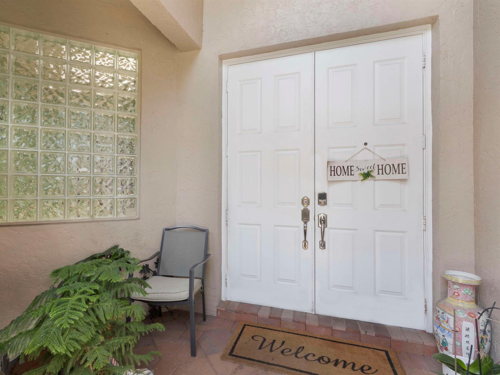 A front entryway features double white doors, a glass block window, a chair, and a mat — 5159 Brookview Drive, Boynton Beach FL 33437, BOYNTON BEACH, FL
