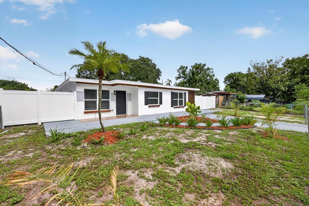 A white single-story house with a palm tree and a white vinyl fence — 4019 MCLANE DRIVE, TAMPA, FL