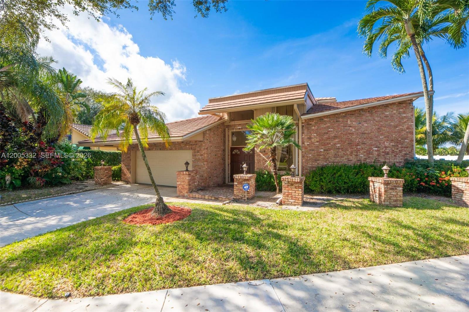 A single-story brick house with a tiled roof, a two-car garage, and palm trees — 6481 Timber Ln, Boca Raton FL 33433, BOCA RATON, FL
