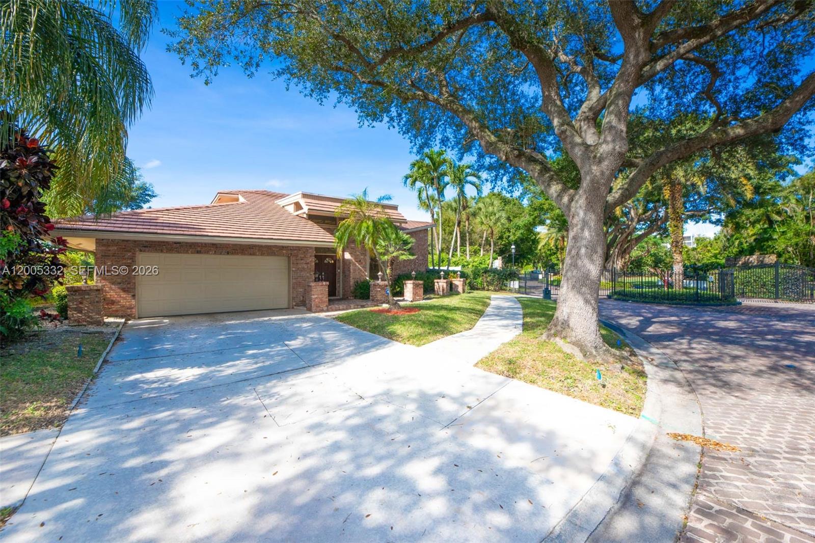 A brick house with a two-car garage sits behind a large tree and driveway — 6481 Timber Ln, Boca Raton FL 33433, BOCA RATON, FL