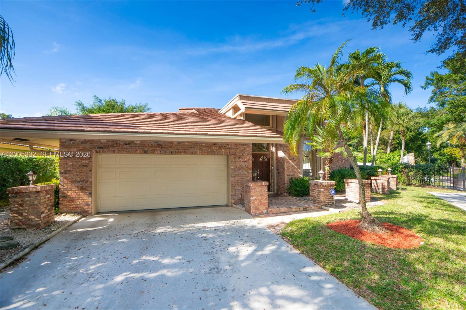 A single-story brick house features a two-car garage, a tiled roof, and a palm tree — 6481 Timber Ln, Boca Raton FL 33433, BOCA RATON, FL