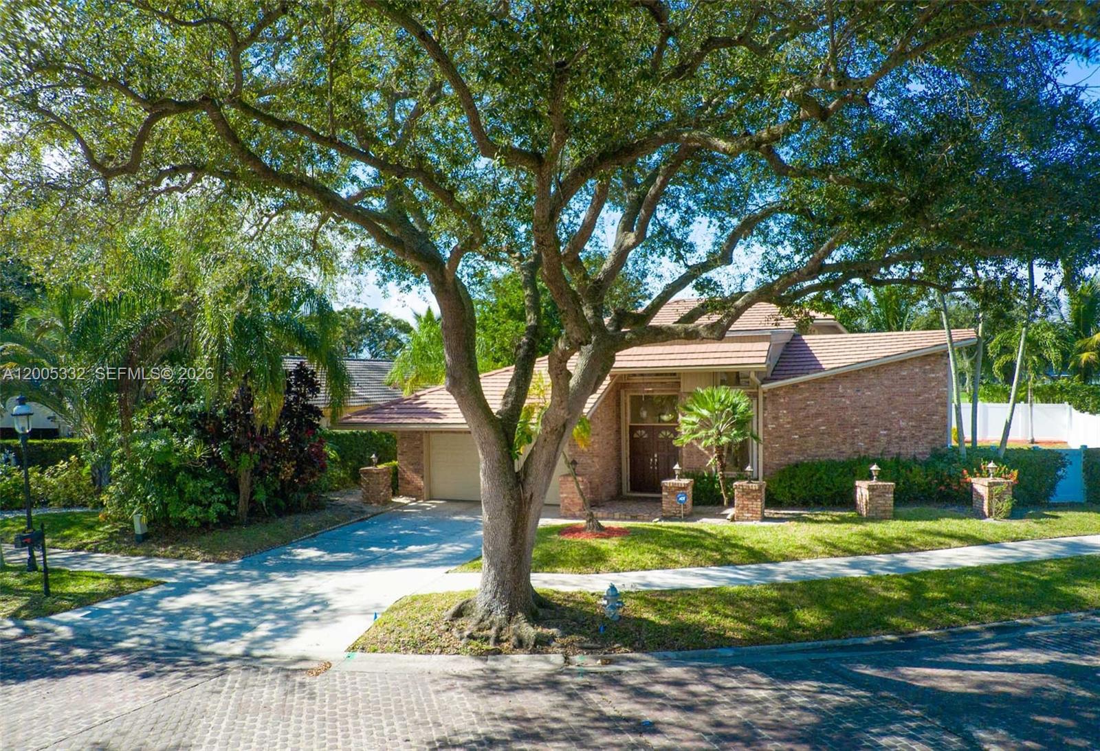 A brick house with a tile roof and a large tree in the front yard — 6481 Timber Ln, Boca Raton FL 33433, BOCA RATON, FL
